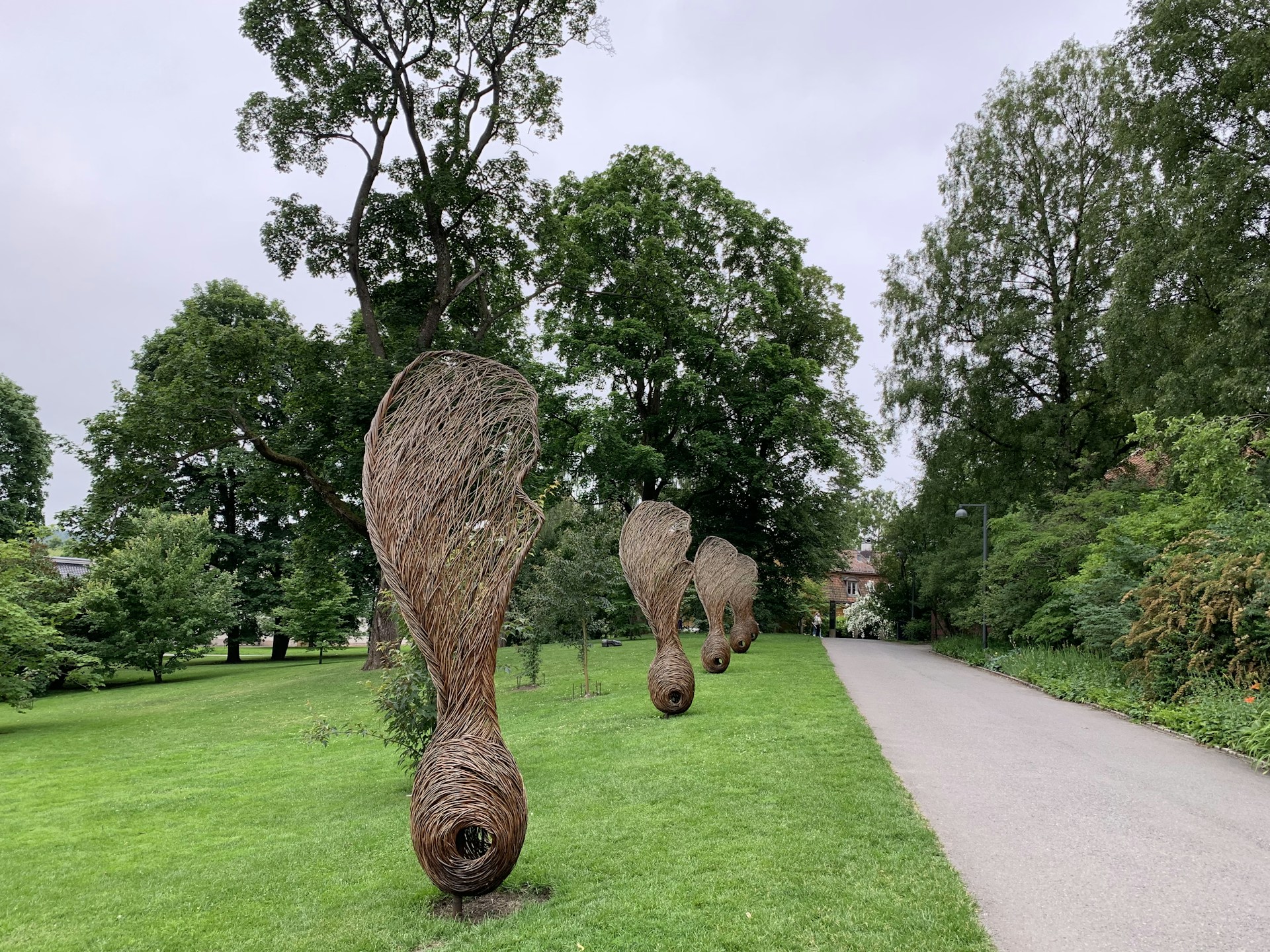 An outdoor exhibition featuring large sculptures surrounded by greenery.