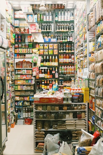Shelves stocked with a variety of packaged food products in a cozy minimarket.