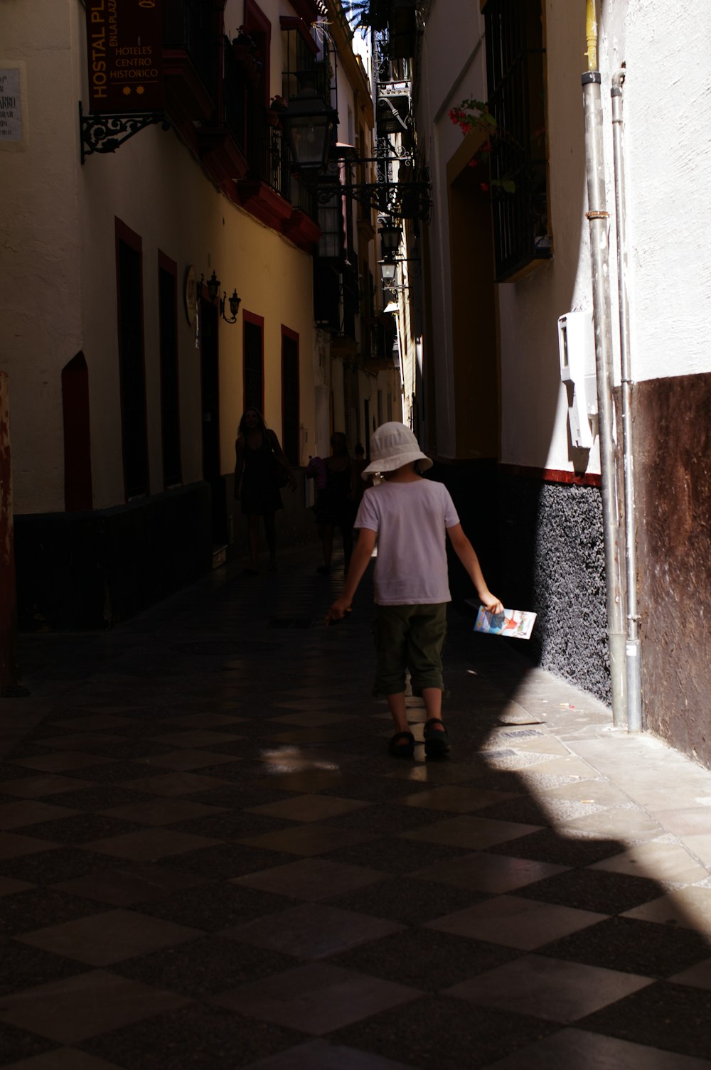 woman in white dress walking on sidewalk during daytime