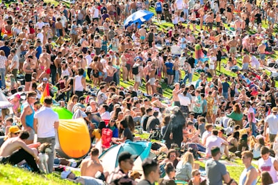 A group of festival-goers chatting beside a bank of lockers on a sunny day.
