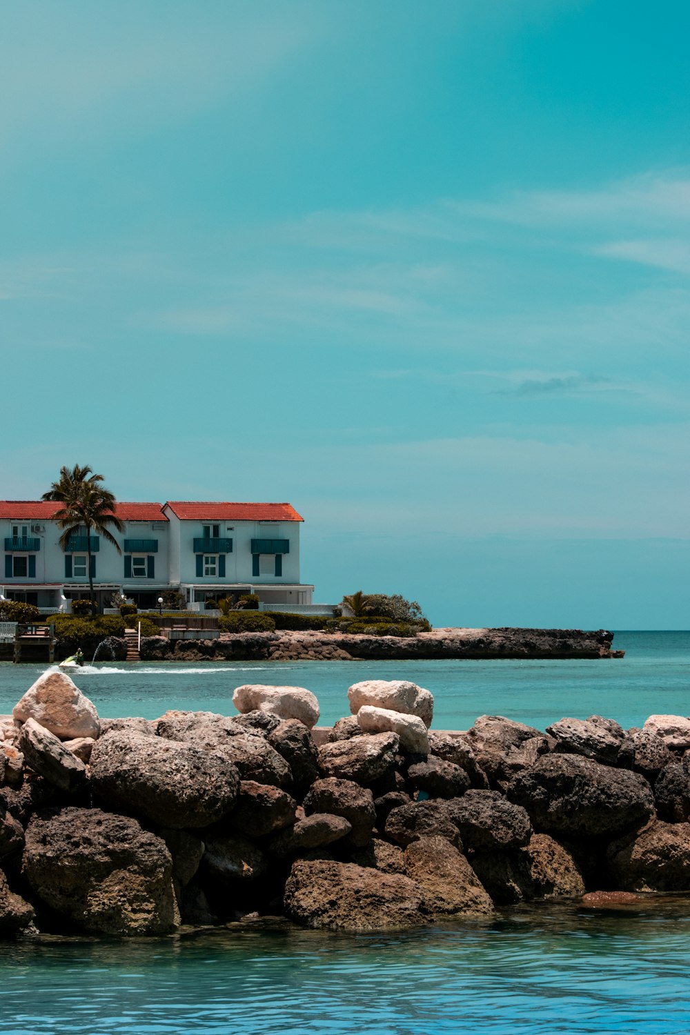 white and red house near body of water during daytime