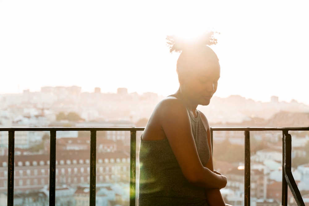 woman in white tank top standing near railings during daytime