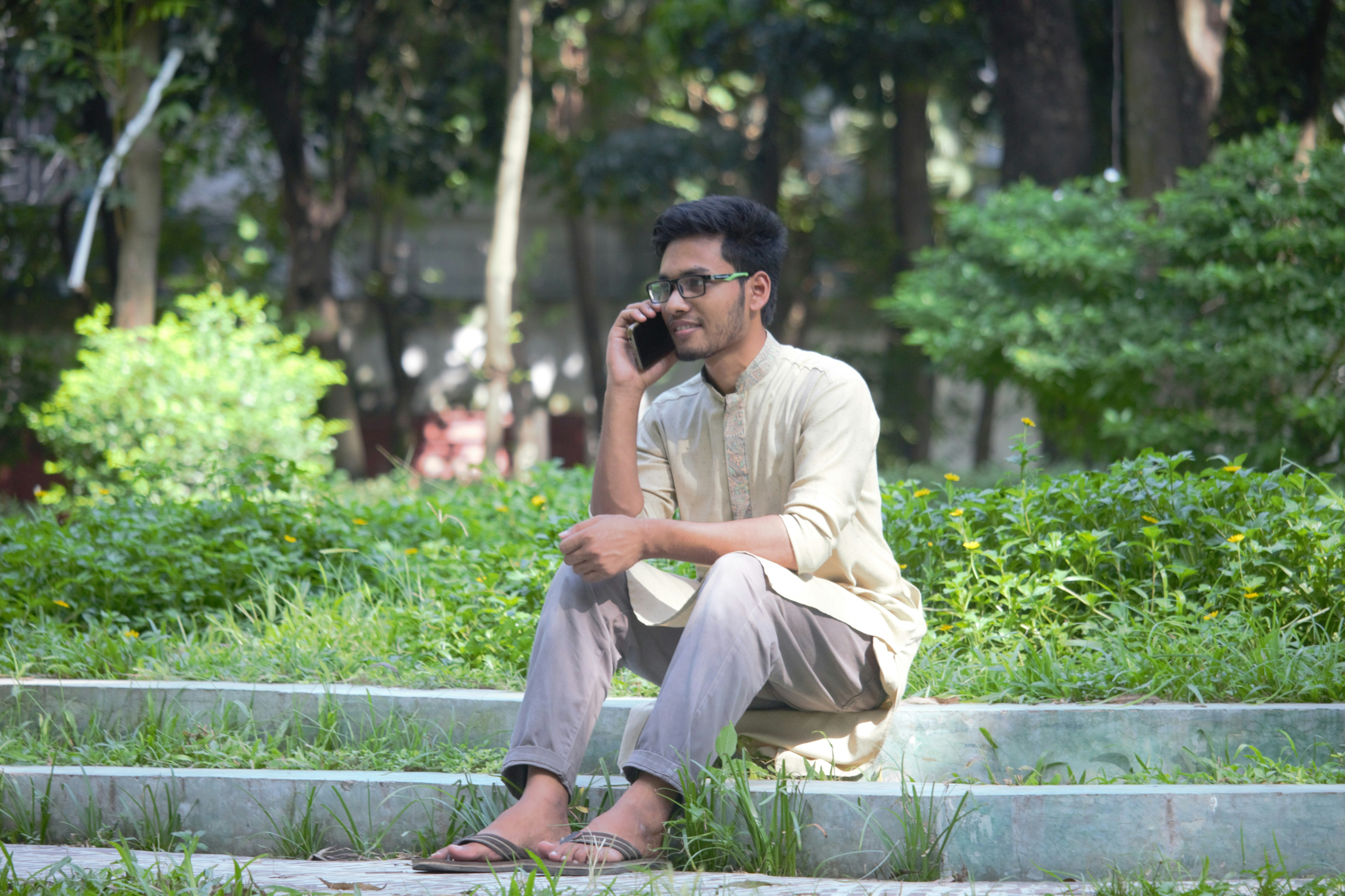 man in beige dress shirt and gray pants sitting on blue wooden bench during daytime