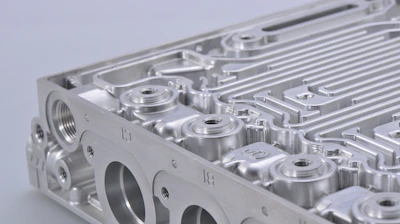 Close-up of steel components being machined with industrial equipment.