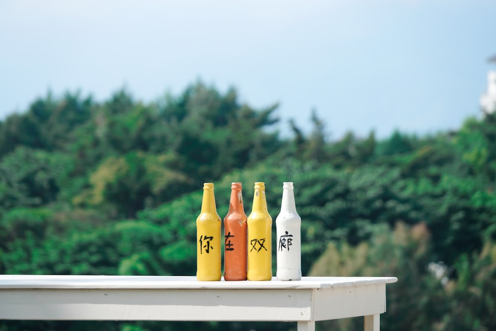 two glass bottles on white wooden table