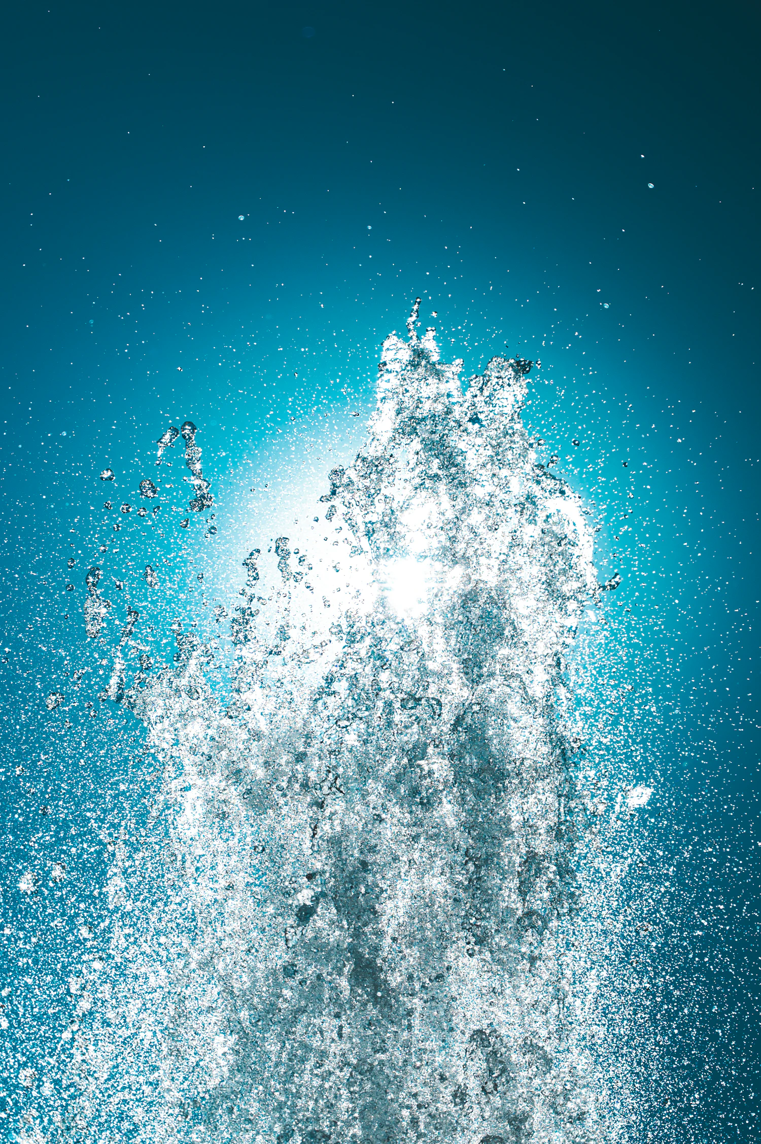 A fan of water bursting upward, every droplet frozen mid-flight