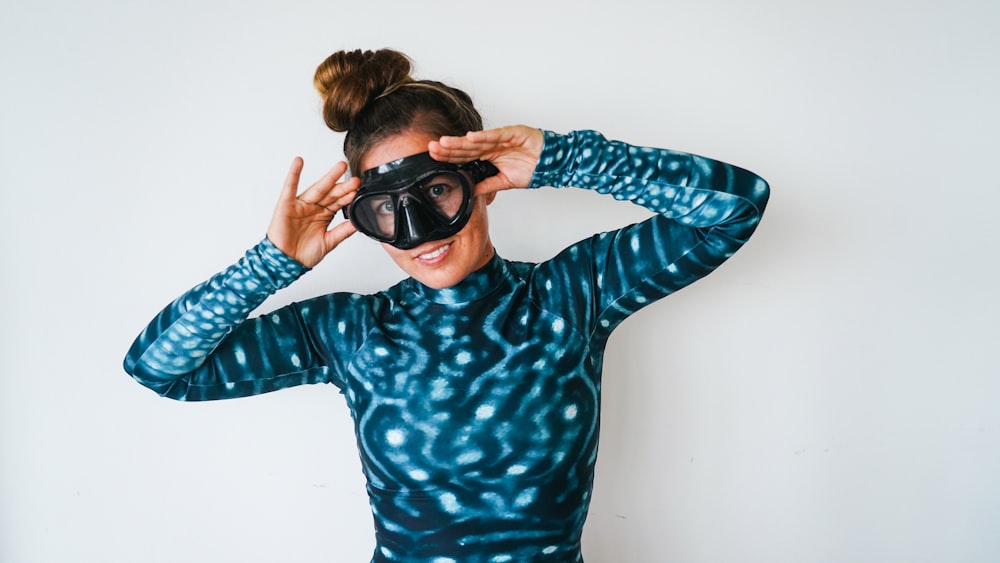 woman in blue and black polka dot long sleeve shirt wearing black sunglasses