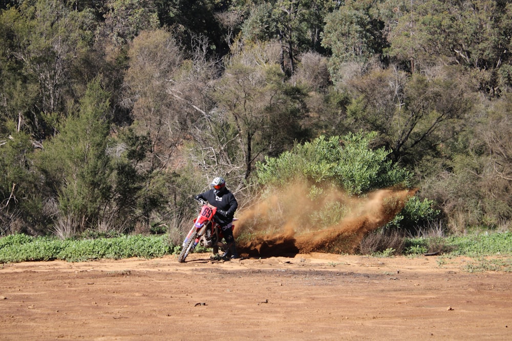 man riding motocross dirt bike on dirt road during daytime