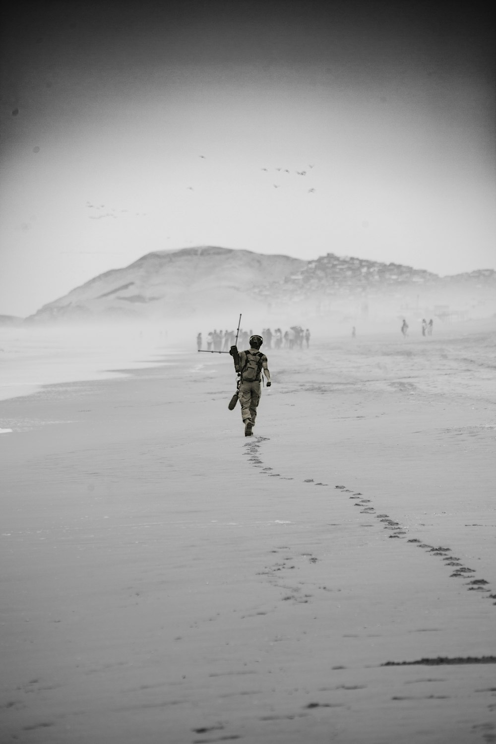 man in black jacket and brown pants walking on snow covered field during daytime