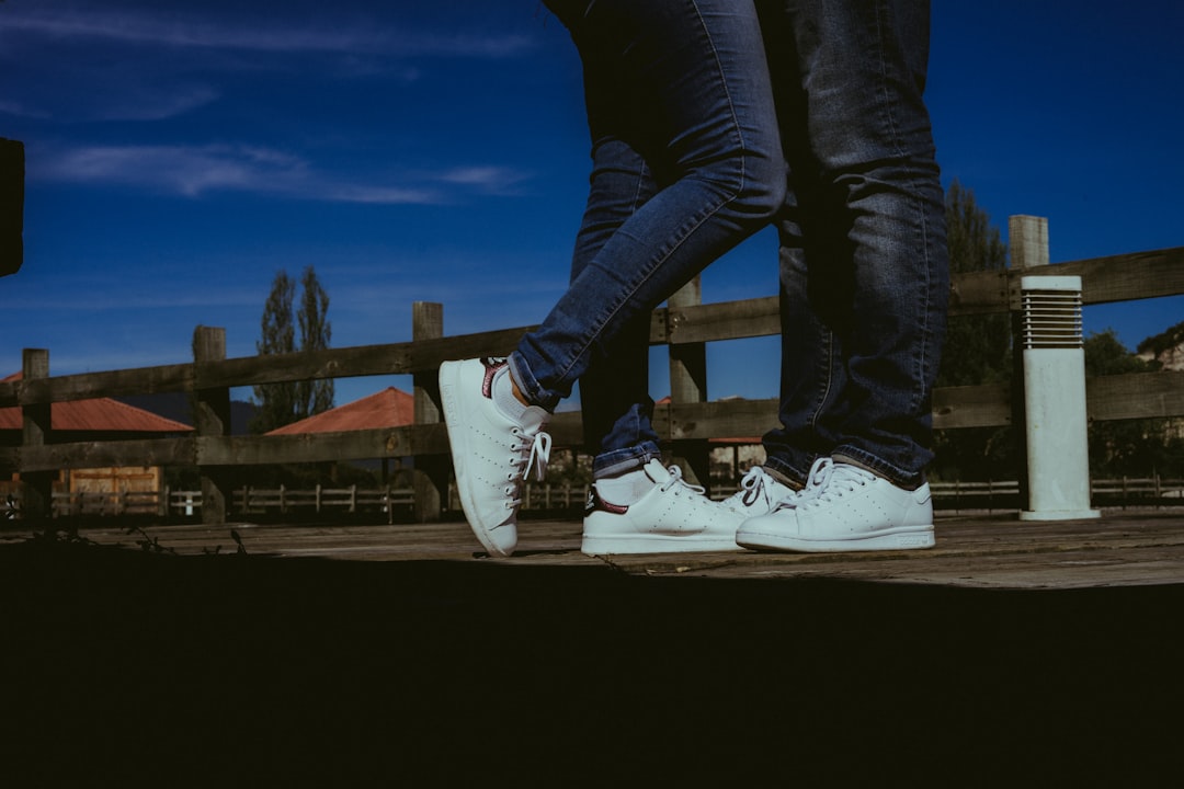 person in blue denim jeans and white nike sneakers