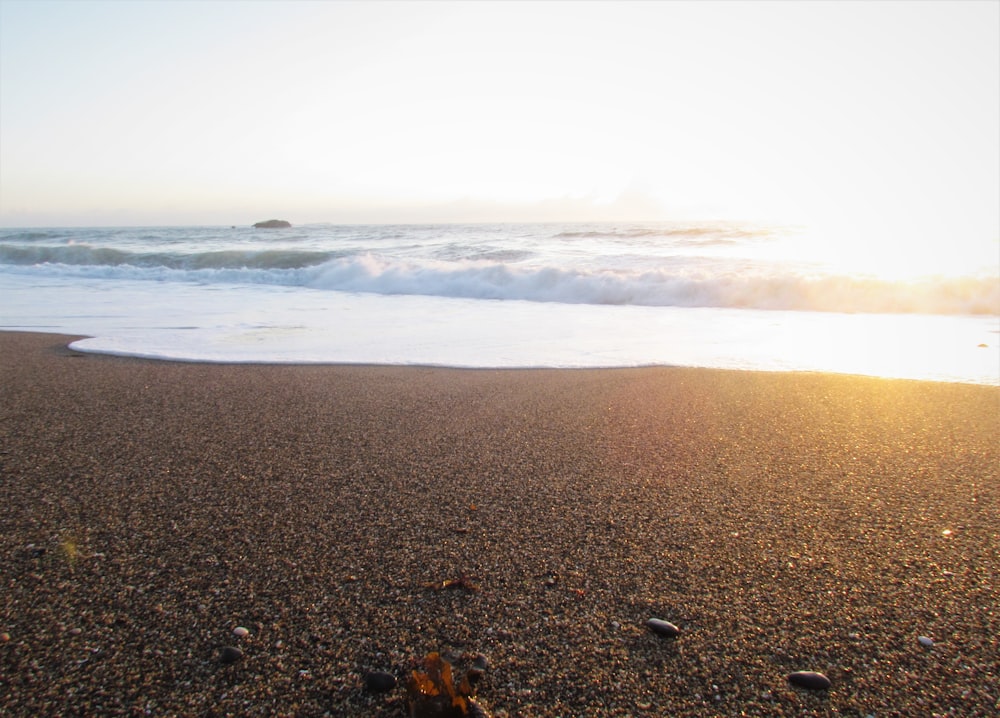 sea waves crashing on shore during daytime