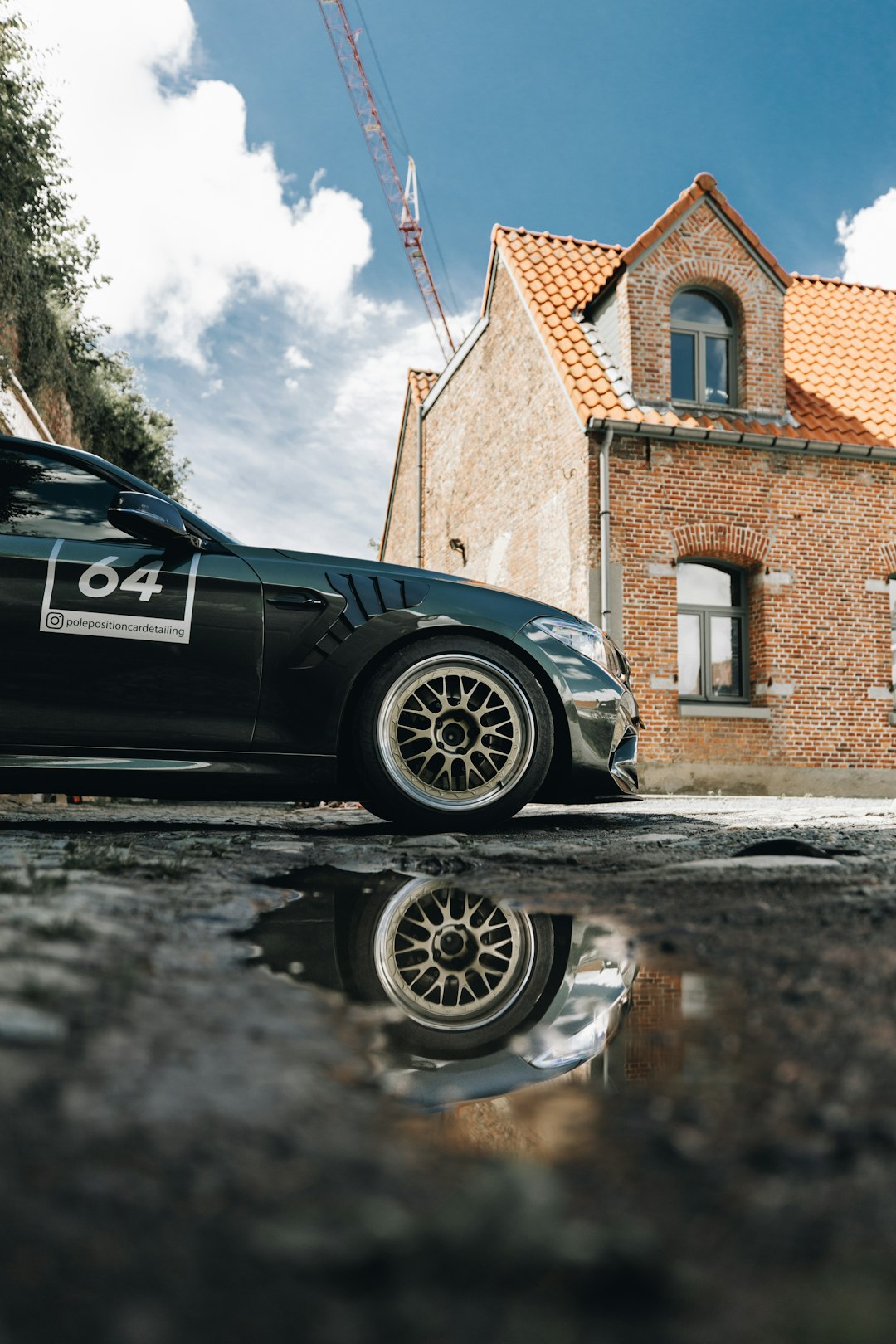 black bmw m 3 coupe parked beside brown brick building during daytime