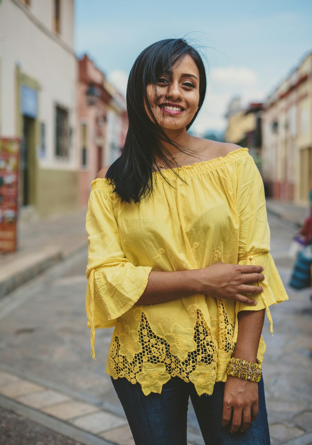 woman in yellow and white floral long sleeve shirt smiling