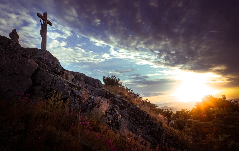 brown wooden cross on top of mountain during daytime