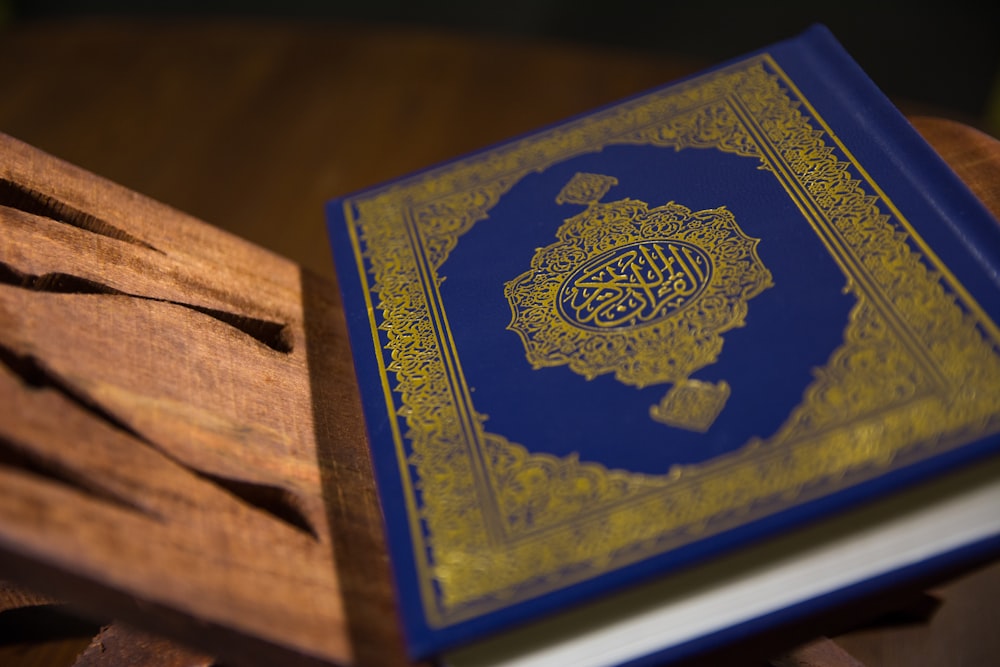 blue and gold book on brown wooden table
