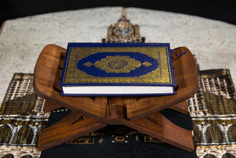blau-weißes Buch auf braunem Holztisch