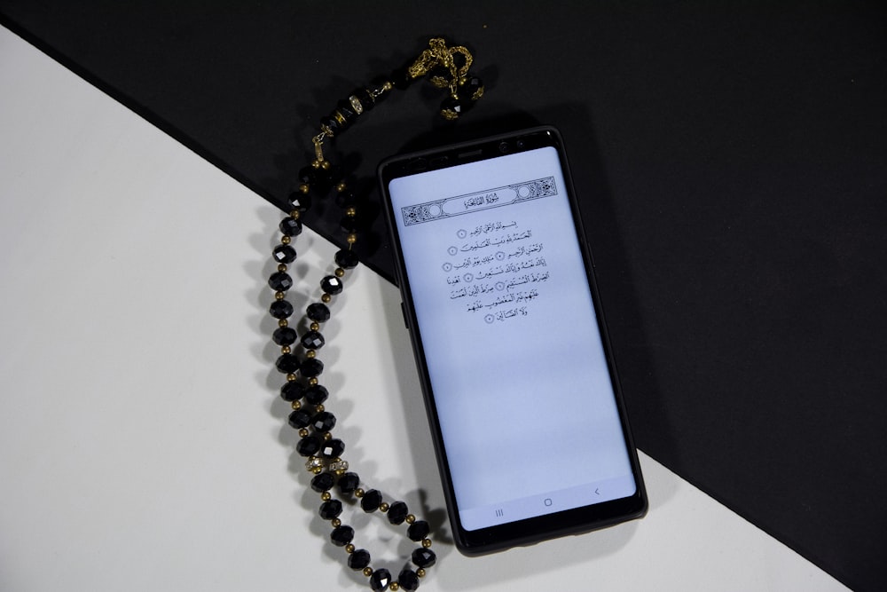 Teléfono inteligente Android negro sobre mesa blanca