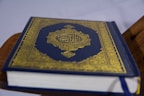 An elegant fancy Quran with a golden cover.