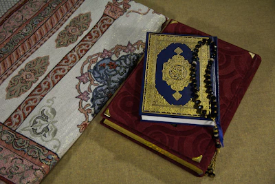 A set of elegant Quranic talismans displayed on a dark emerald green silk fabric