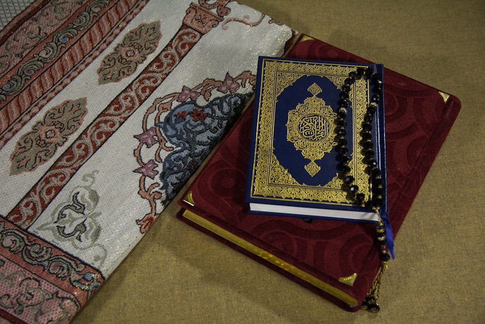Rotes und blaues Buch auf weißem und blauem Blumentextil