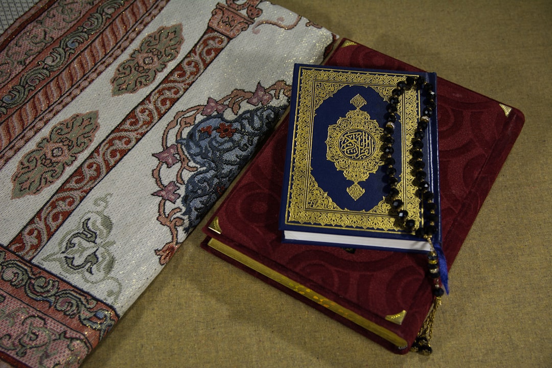 red and blue book on white and blue floral textile