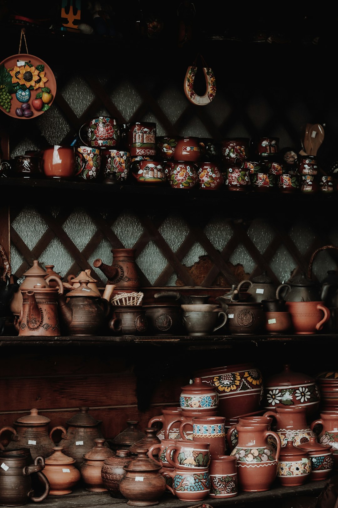 brown and black ceramic mugs on brown wooden shelf