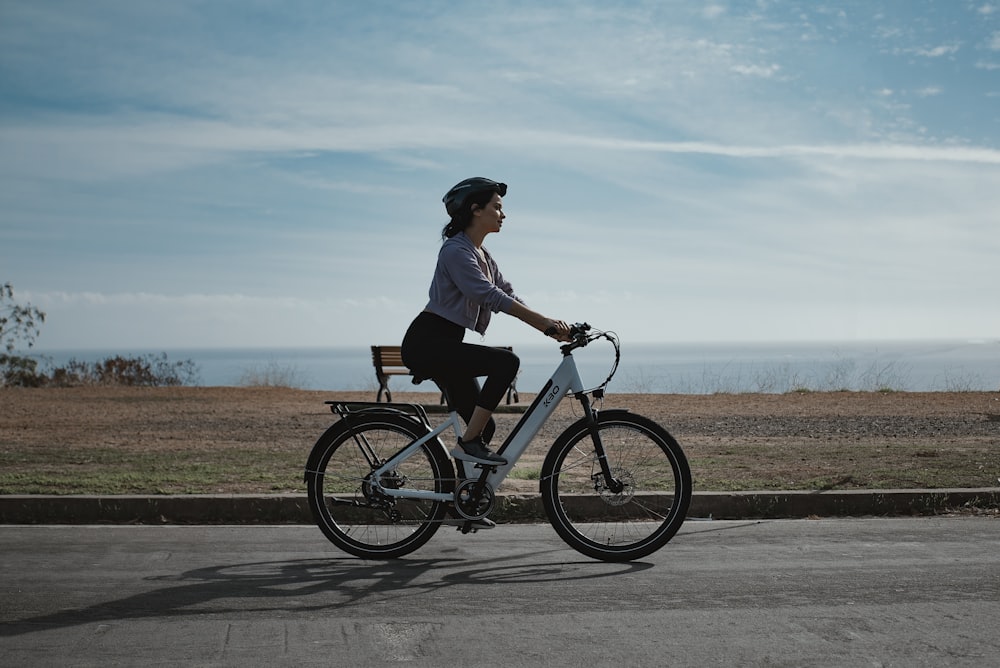 man in gray shirt riding bicycle on road during daytime