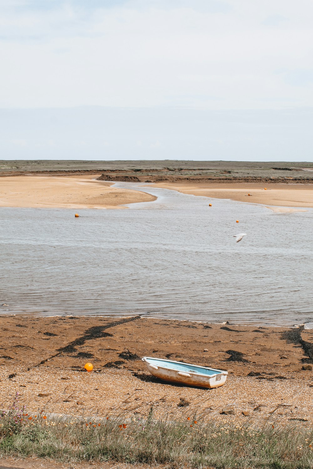 Barco blanco y marrón en la orilla del mar durante el día
