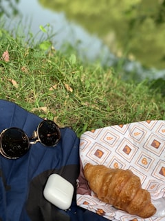 Waterproof blanket protecting a picnic area from damp grass on a sunny day.