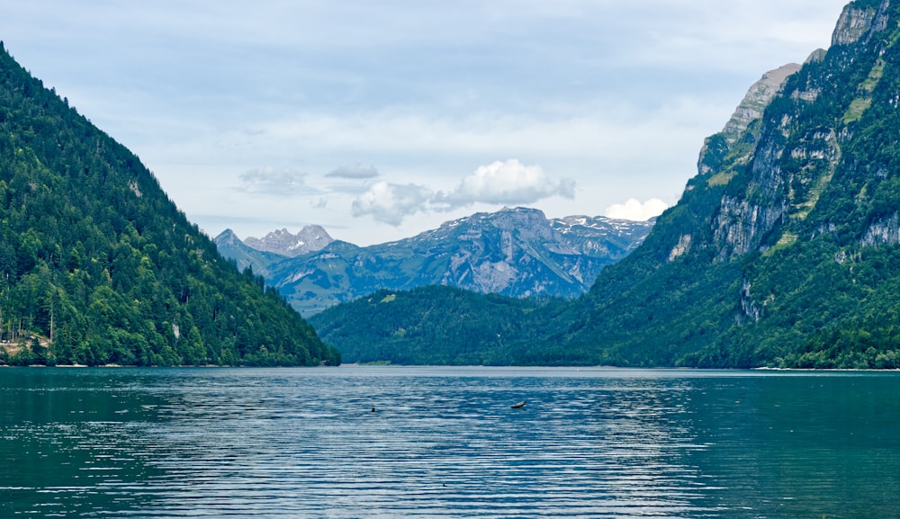 body of water near mountain during daytime