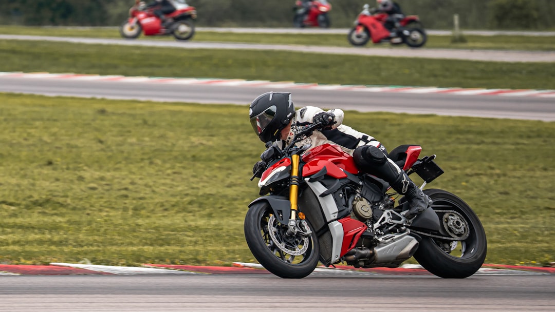 man in orange and black motorcycle suit riding on orange and black motorcycle