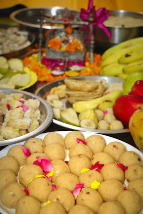 Close-up of hands offering fruits and sweets during the puja ceremony.