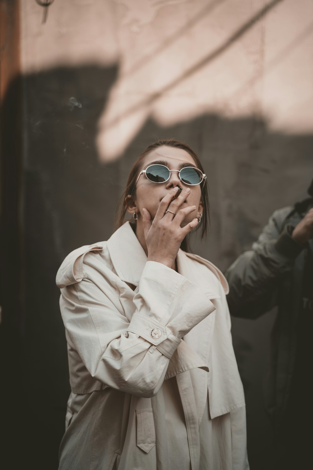 woman in white coat wearing blue sunglasses