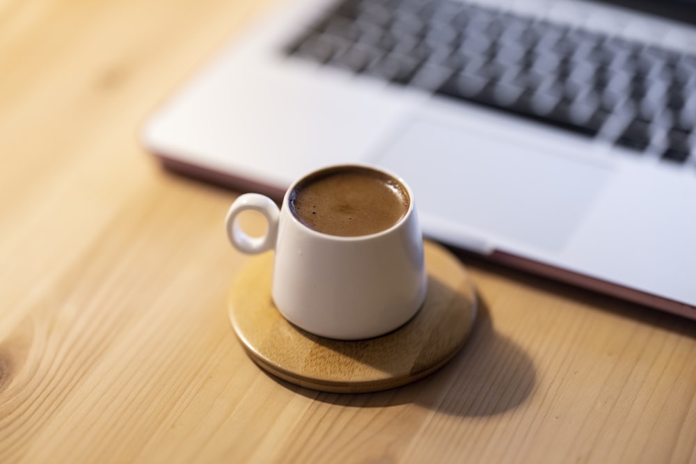 white ceramic mug on brown coaster