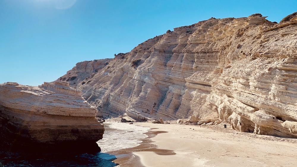 brown rock formation near body of water during daytime