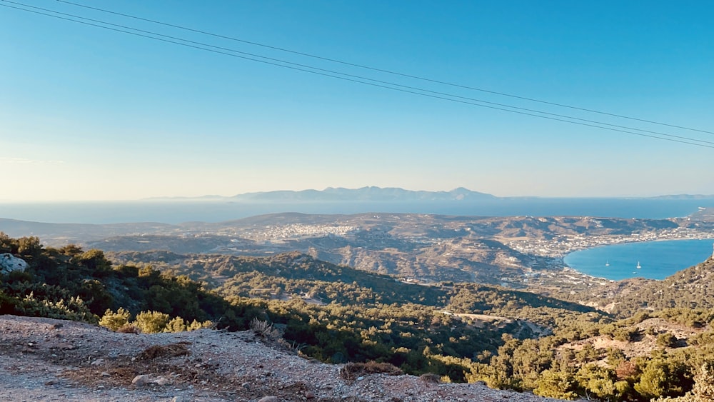 árvores verdes e montanhas sob o céu azul durante o dia