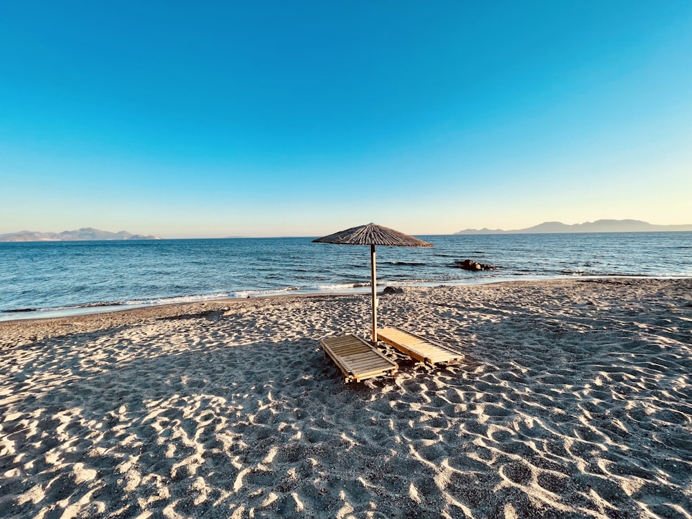 낮 동안 해변에 갈색 나무 해변 라운지 의자