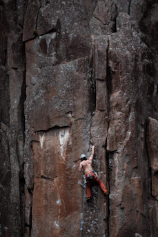 Climber securing a harness before ascending a steep cliff