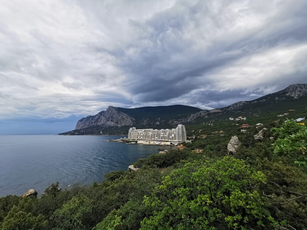 white concrete building on top of mountain near body of water during daytime