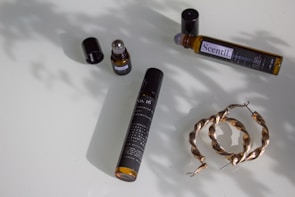 Minimalist flat lay of car and room sprays with soft golden light reflections.