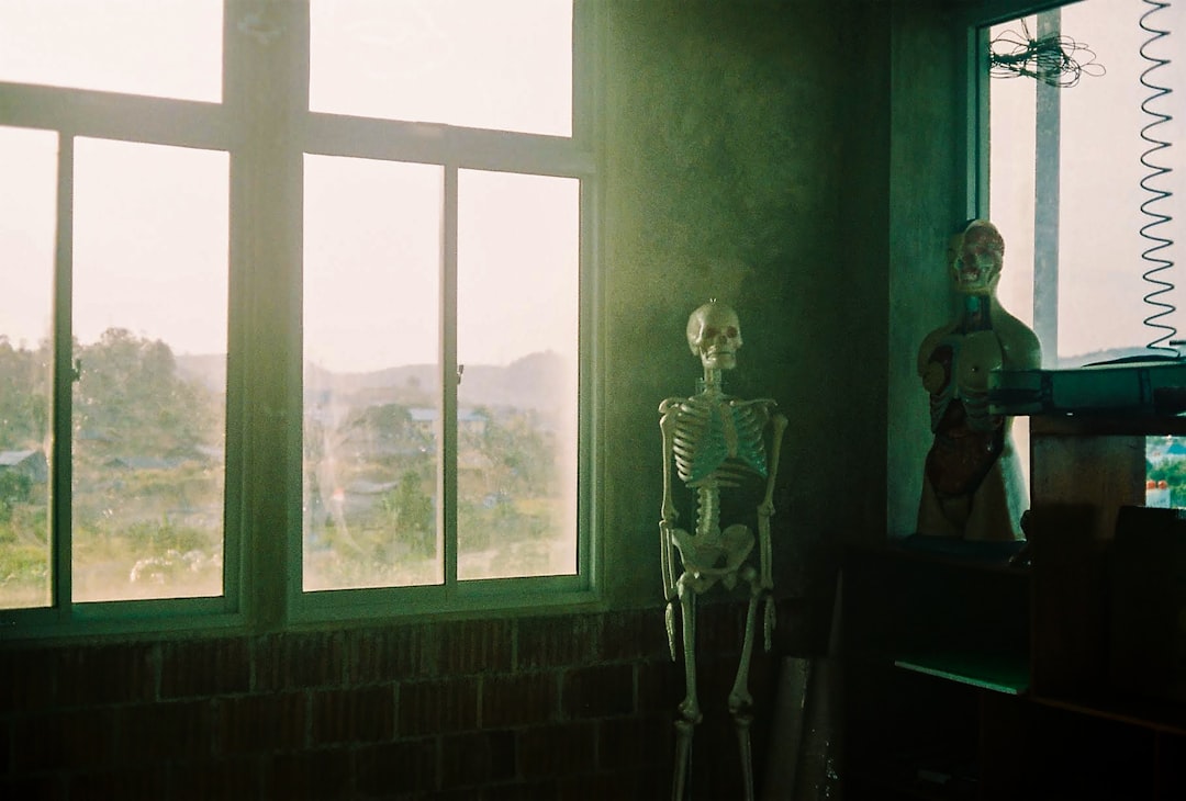 woman in gold and black dress standing beside window