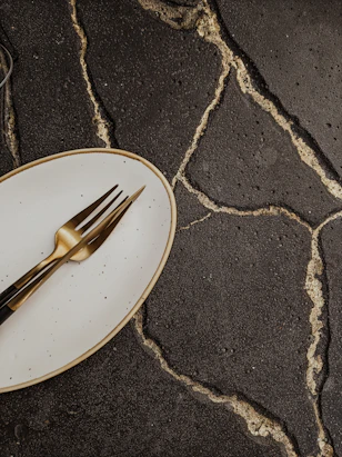 stainless steel fork on white and black ceramic plate