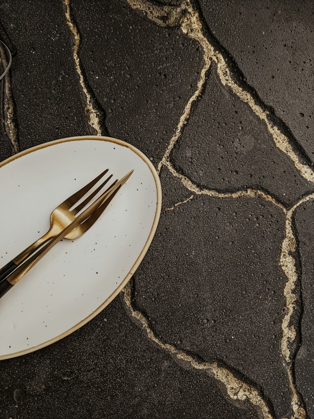 stainless steel fork on white and black ceramic plate