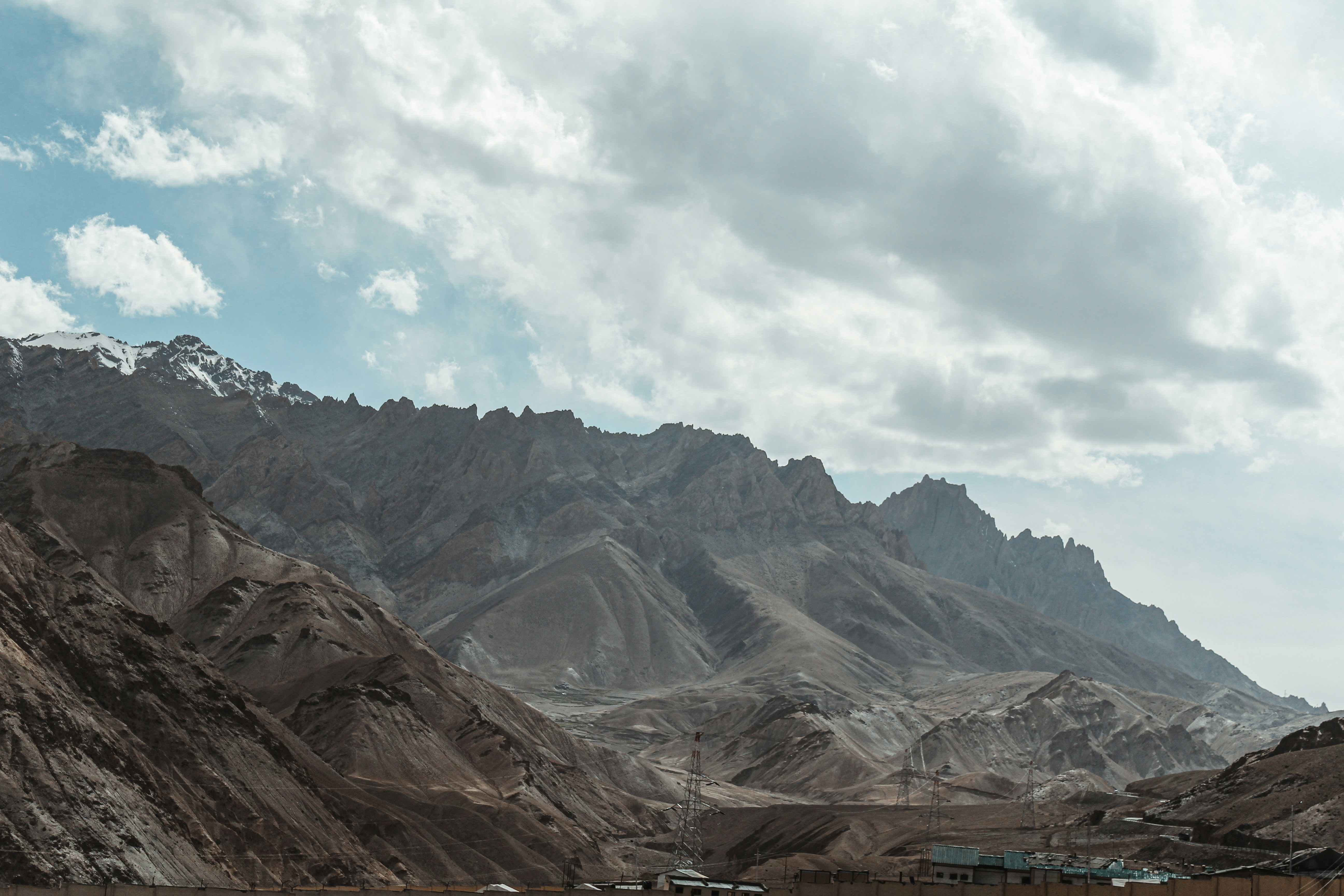 brown and gray mountains under white clouds and blue sky during daytime