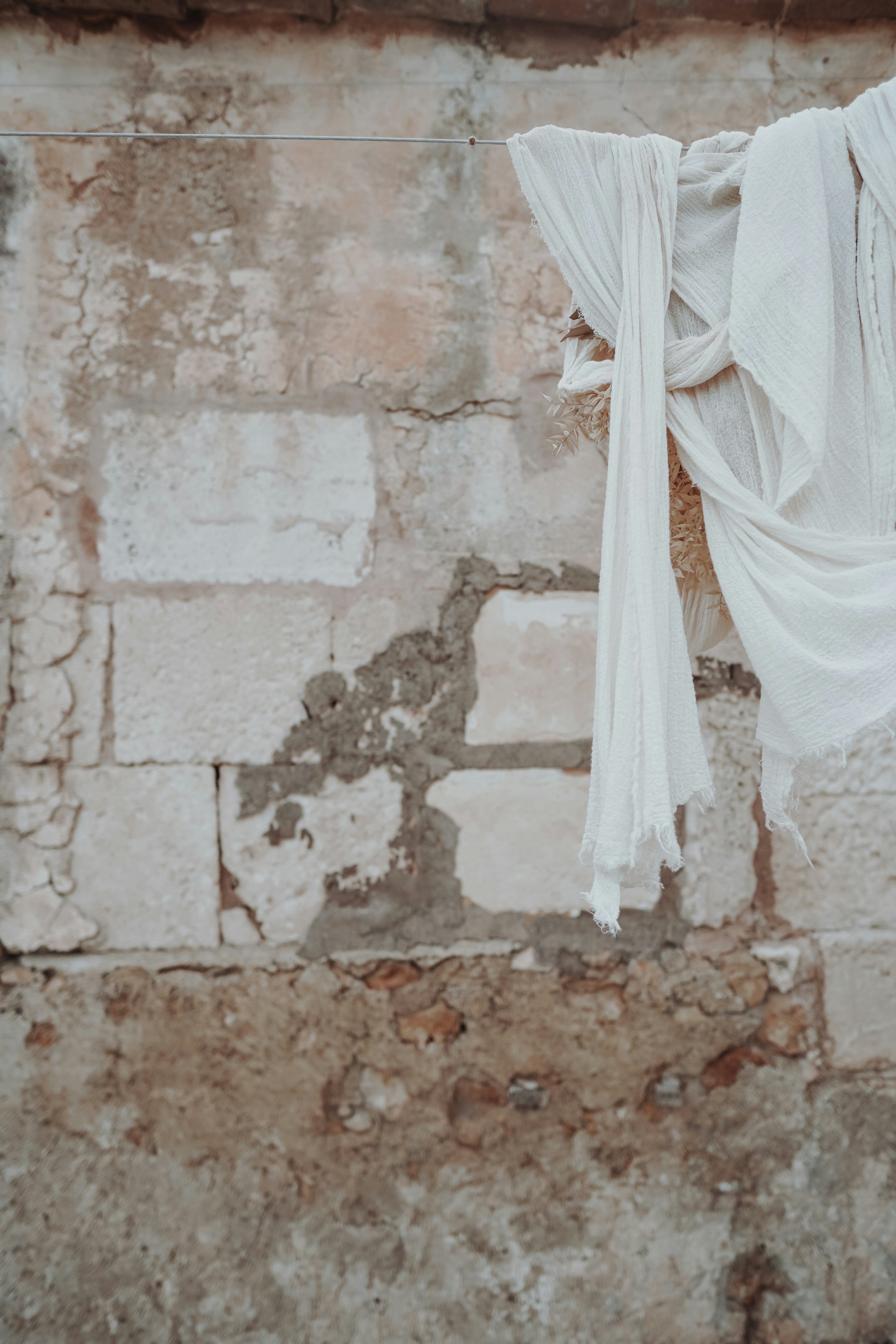 textil blanco sobre pared de hormigón marrón