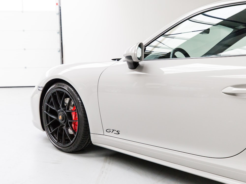 white porsche 911 parked in a room