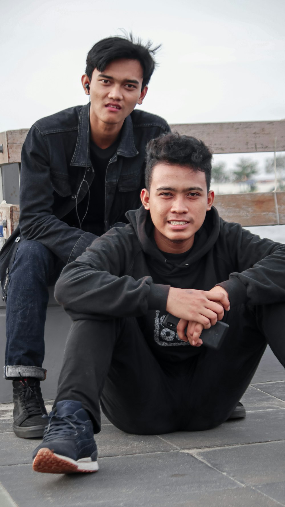 man in black zip up jacket sitting beside man in black jacket