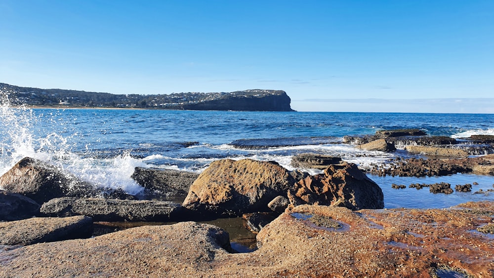 ocean waves crashing on rocky shore during daytime