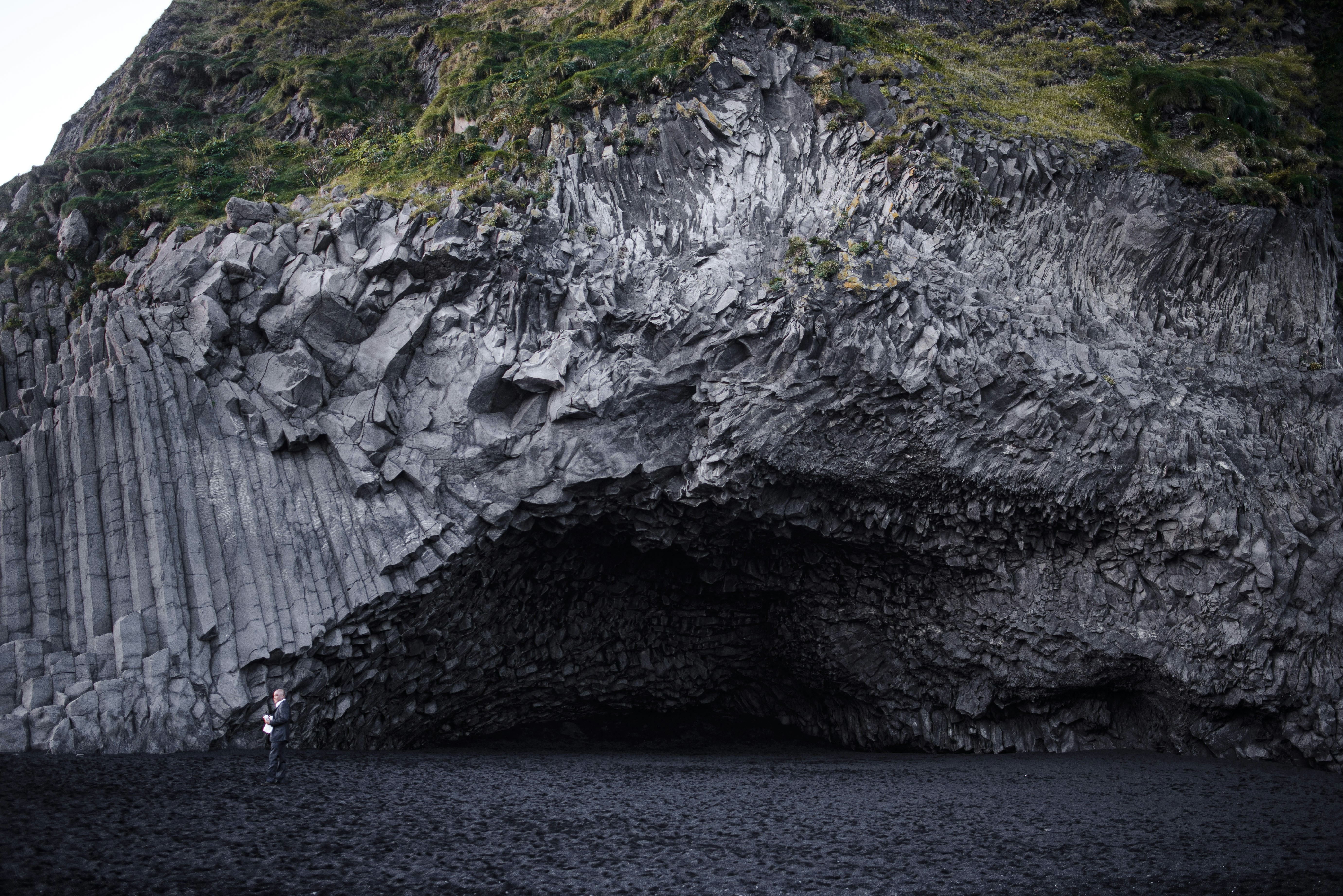 gray rock formation beside body of water during daytime