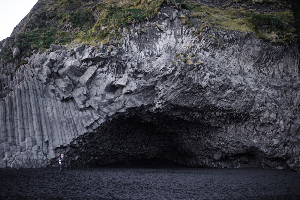 gray rock formation beside body of water during daytime